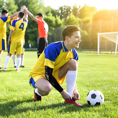 Un homme porte le manchon de compression bras - RegenBras durant une partie de foot