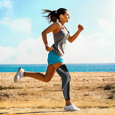 Une femme court sur la plage avec les manchons de compression - PulseFit aux genoux