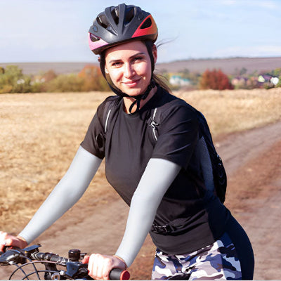 Une femme fait du vélo et porte le manchon pour les bras - OxyFlow