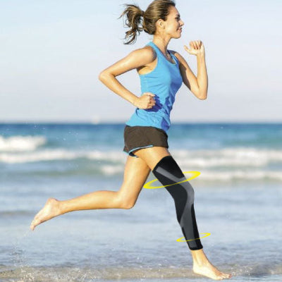 Une femme gambade sur le bord de l'eau avec ses manchons de compression - PulseFit aux genoux