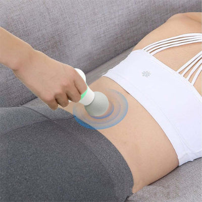 Une femme masse le bas de son dos avec le pistolet masseur - PowerPulse
