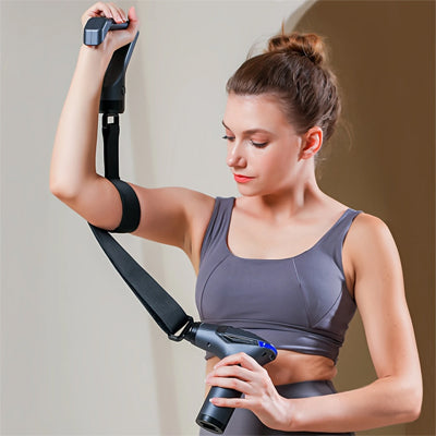 Une femme utilise le pistolet masseur -  PulseÉlite, fixé autour de son bras, pour cibler la détente musculaire en profondeur
